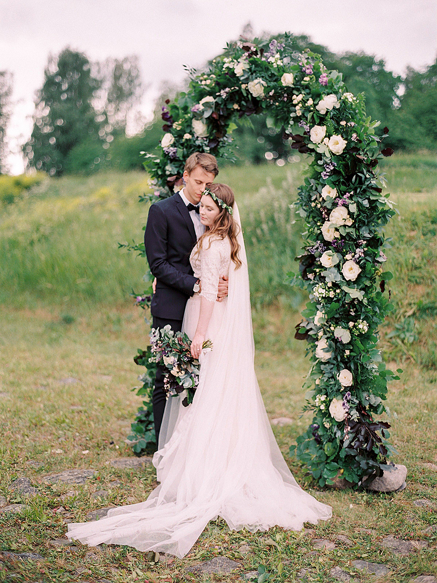 Bride and groom in front of the floral arbor