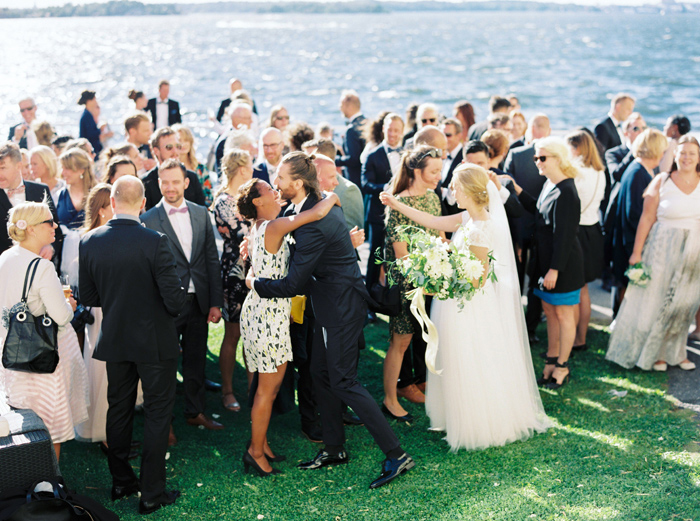 Guests hugging and toasting for bride and groom outdoors wedding Ekensdal Stockholm