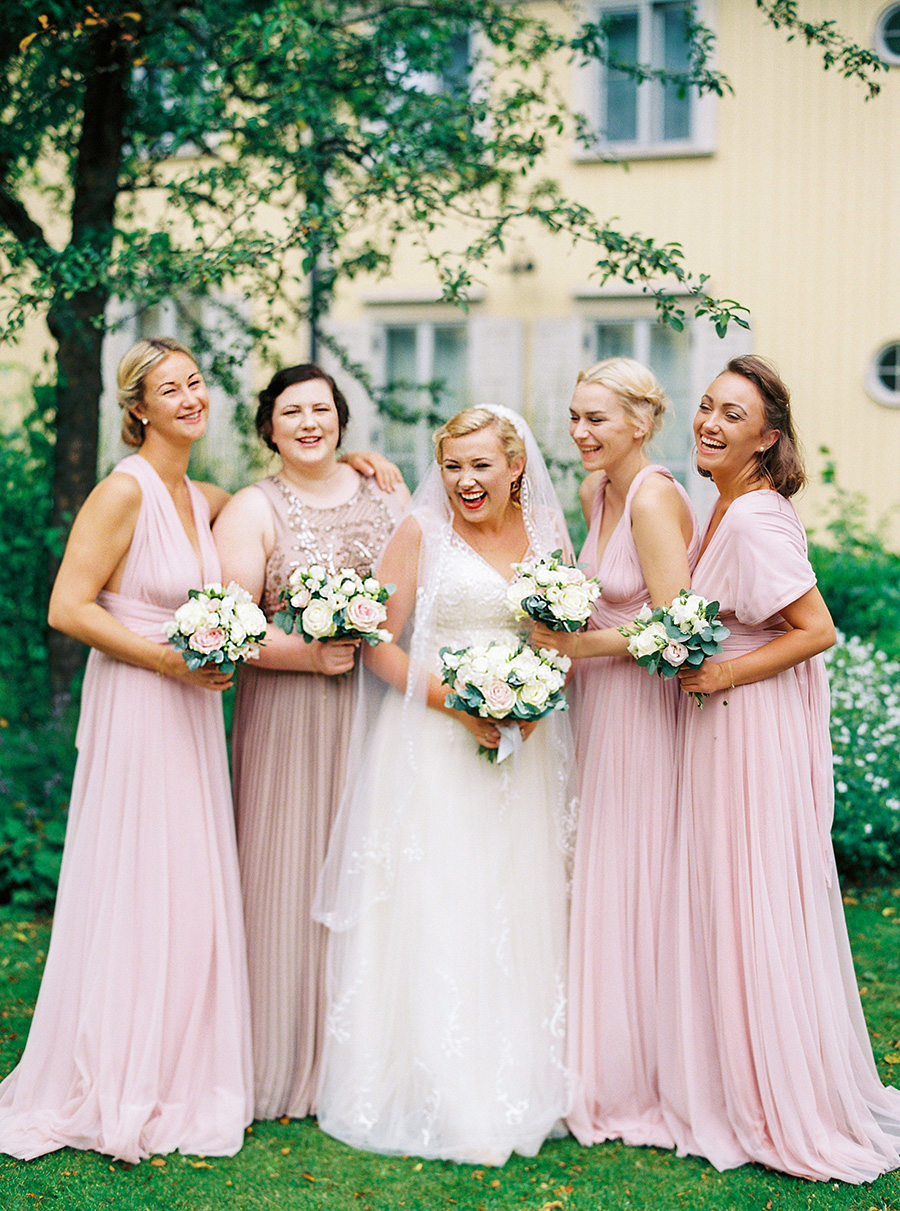 Bridesmaids dressed in pink gowns with the bride having fun.