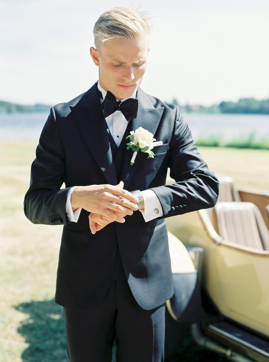 Groom looking at his watch checking the time for the bride to arrive at Södertuna Slott