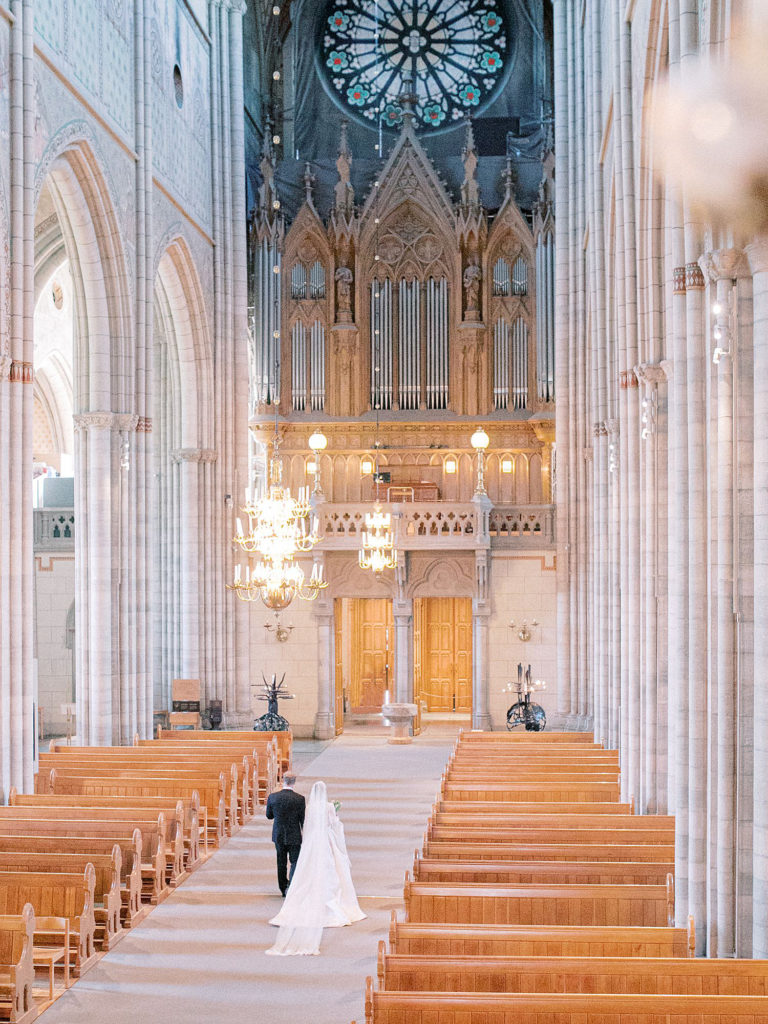The bride and groom are walking down the isle and you can see the full grandeur of Uppsala Domkyrka.